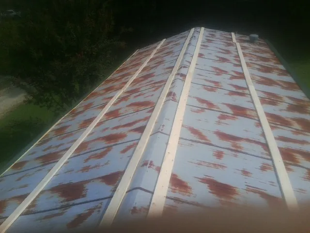 Rusted metal roof panels with new wood purlins before replacement — Storm Damage Roof Repair in Nashua by Roofing Brothers