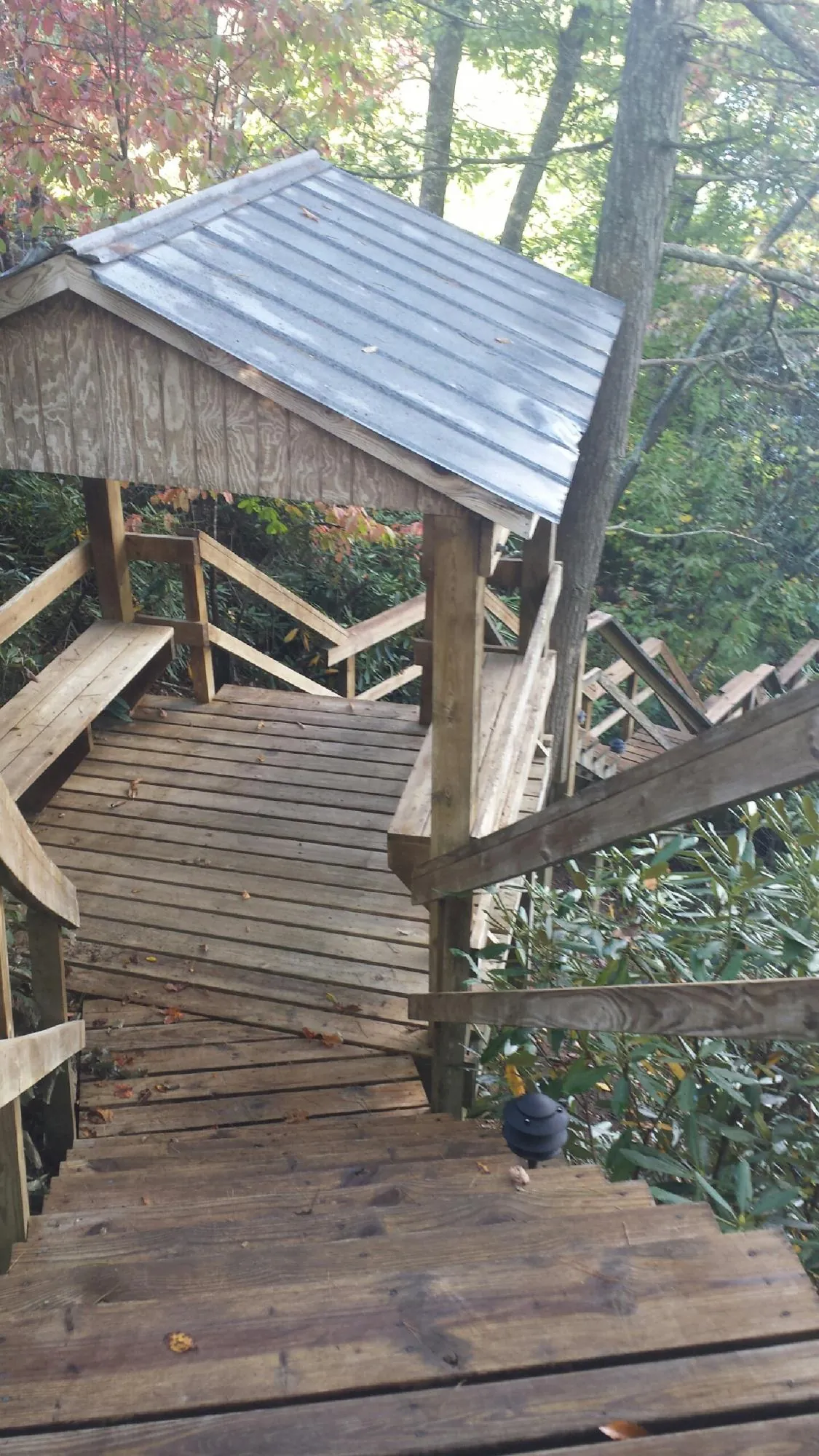 Metal roofed shelter over wooden steps on a wooded walkway — Skylight Repair & Installation work by our crew in Nashua